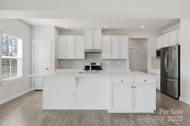 a kitchen with a refrigerator sink and cabinets