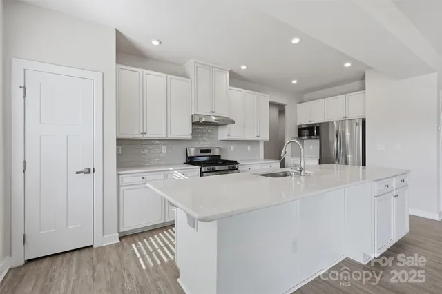 a kitchen with stainless steel appliances sink refrigerator and cabinets