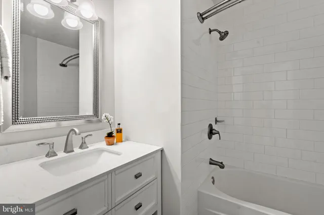 a bathroom with a sink double vanity granite tub shower and mirror