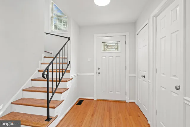 a view of a hallway with wooden floor and entryway