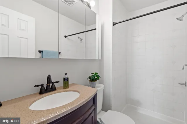 a bathroom with a sink toilet a mirror and shower