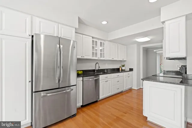 a kitchen with stainless steel appliances a refrigerator sink and cabinets