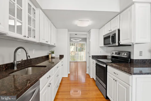 a kitchen with granite countertop stainless steel appliances and cabinets