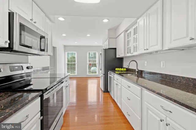 a kitchen with stainless steel appliances granite countertop a sink stove and cabinets