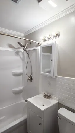 a bathroom with a sink a toilet and shower