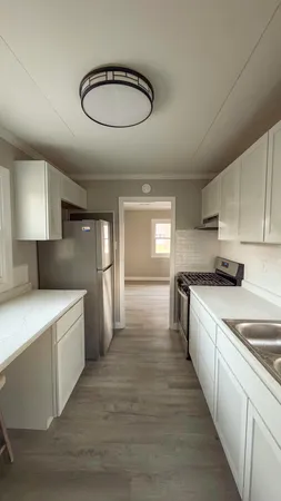 a kitchen with stainless steel appliances a sink a stove a refrigerator and cabinets