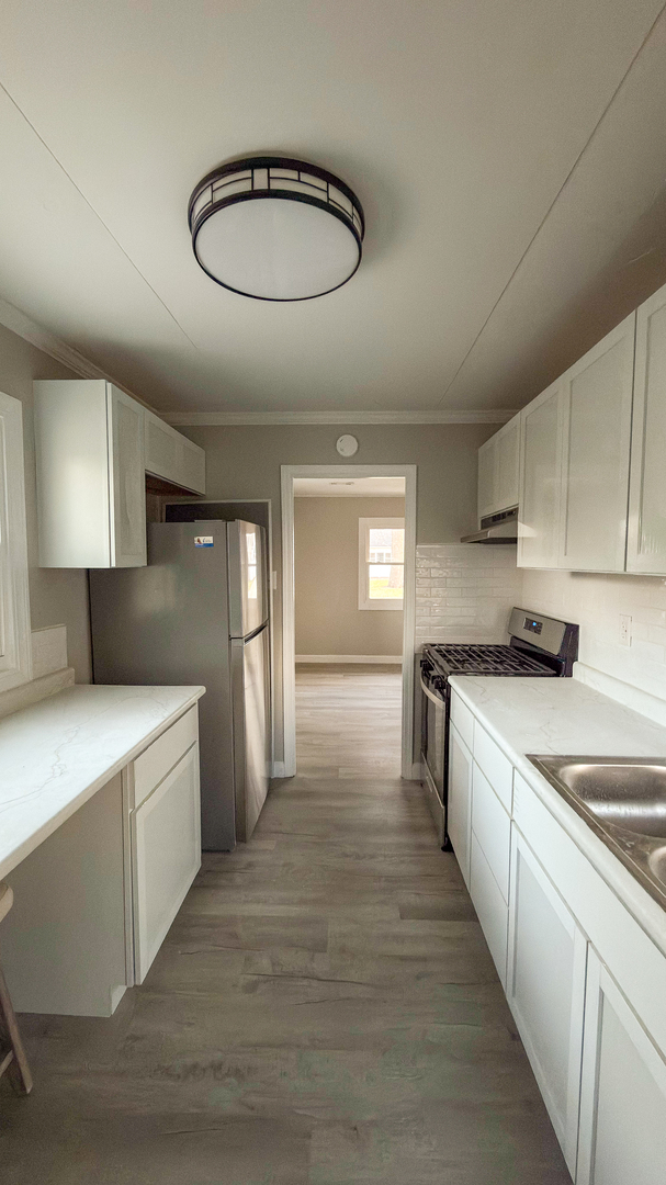 1037 Eastview Drive Rantoul, IL 61866 - Photo 20 of 21 a kitchen with stainless steel appliances a sink a stove a refrigerator and cabinets