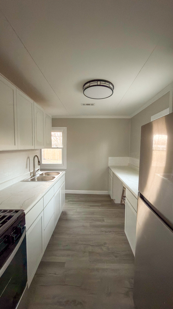 1037 Eastview Drive Rantoul, IL 61866 - Photo 21 of 21 a view of a kitchen with a sink stove and cabinets