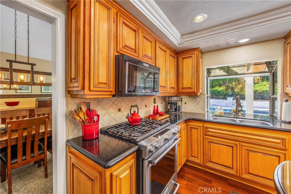 7751 Jack Rabbit Lane Highland, CA 92346 - Photo 12 of 50 a kitchen with stainless steel appliances granite countertop a stove a sink dishwasher and cabinets with wooden floor