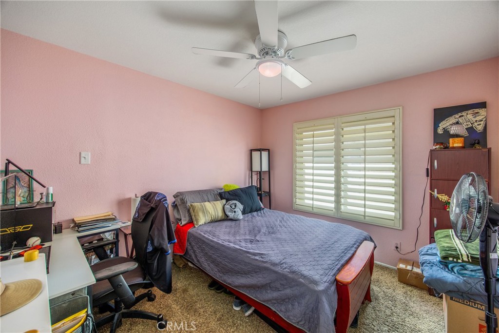 7751 Jack Rabbit Lane Highland, CA 92346 - Photo 30 of 50 a bedroom with a bed bookshelf and a window