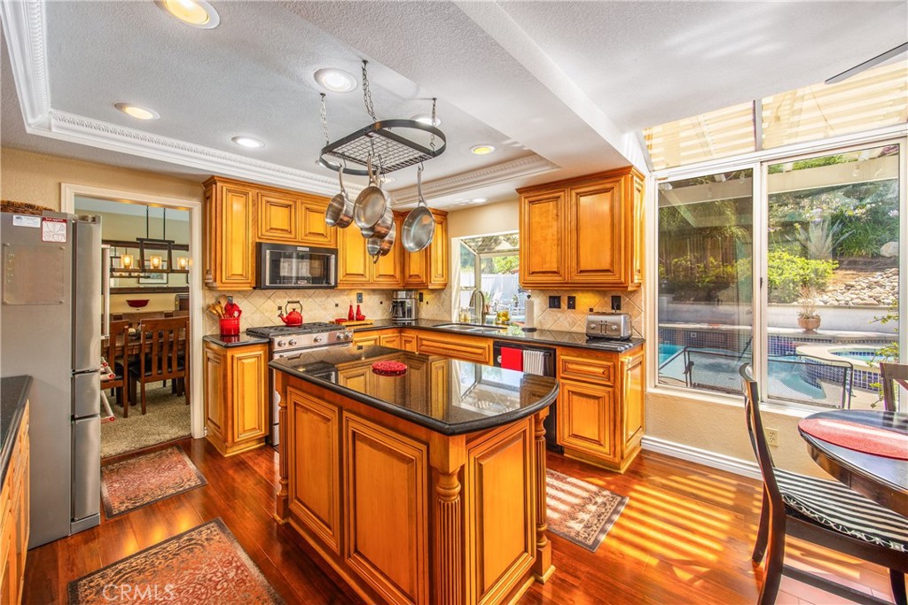 7751 Jack Rabbit Lane Highland, CA 92346 - Photo 3 of 50 a kitchen with stainless steel appliances granite countertop a sink a stove and a refrigerator