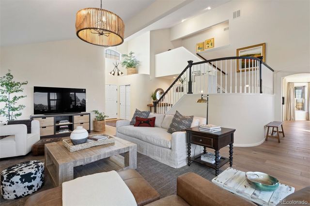a living room with furniture a flat screen tv and a chandelier