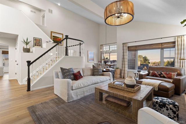 a living room with furniture a rug potted plant and a large window