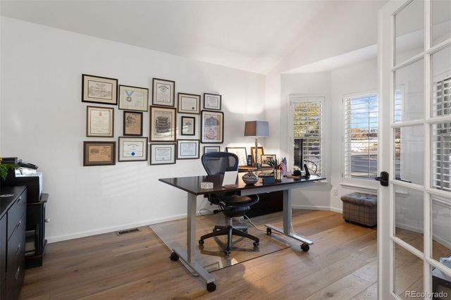 a view of a workspace with furniture and a window