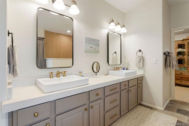 a bathroom with double vanity sinks and a mirror