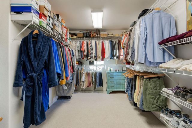 a view of walk in closet with clothes and shoes