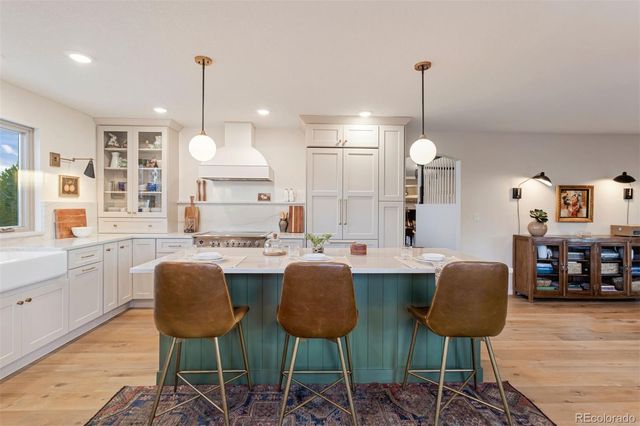 a view of kitchen with stainless steel appliances granite countertop cabinets and chairs