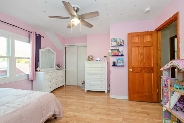 a bedroom with a bed dresser and a window