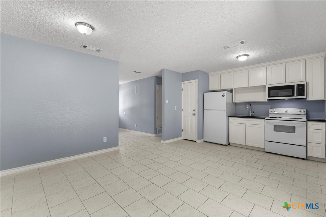 104 East Arlo Road Harker Heights, TX 76548 - Photo 11 of 35 a kitchen with white cabinets and stainless steel appliances