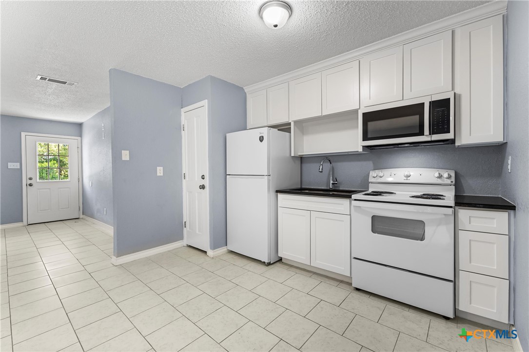 104 East Arlo Road Harker Heights, TX 76548 - Photo 13 of 35 a kitchen with stainless steel appliances granite countertop a refrigerator and a stove top oven