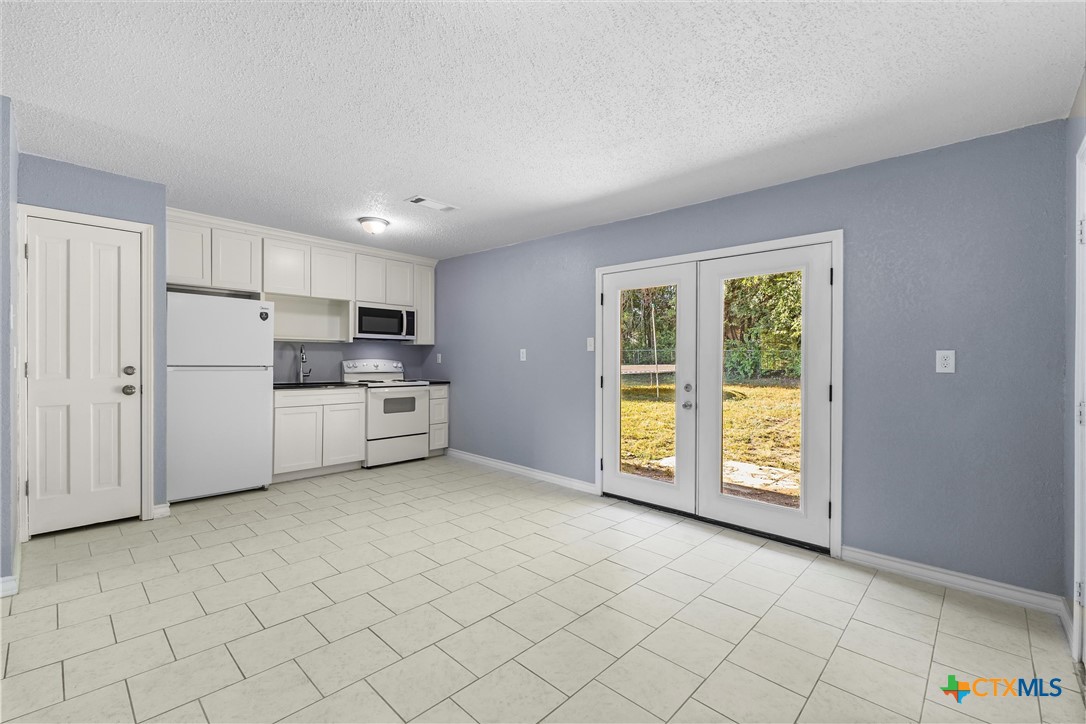 104 East Arlo Road Harker Heights, TX 76548 - Photo 14 of 35 a view of kitchen with stainless steel appliances granite countertop a stove a sink and a refrigerator with white cabinets