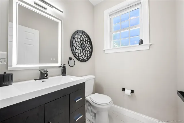 a bathroom with a toilet sink and mirror