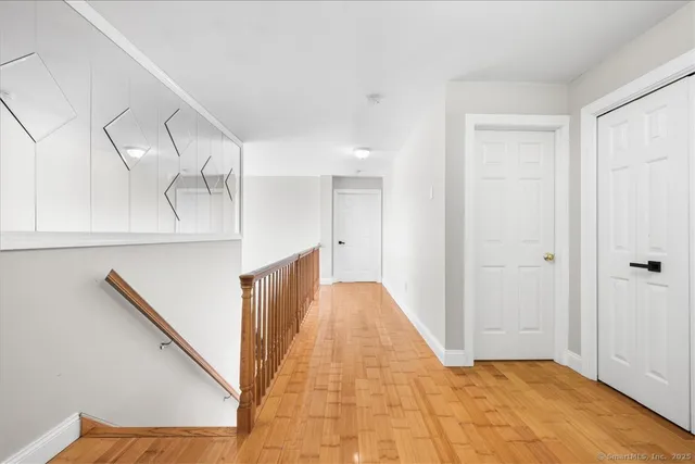 a view of a hallway with wooden floor and staircase