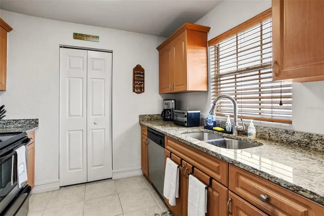 a kitchen with stainless steel appliances granite countertop a sink a stove and a refrigerator