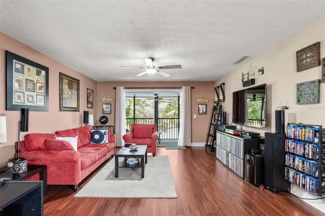 a living room with furniture a flat screen tv and a bookshelf