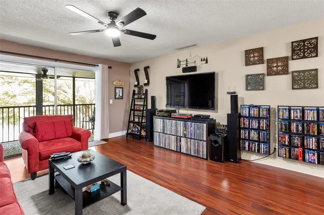 a living room with furniture a flat screen tv and a floor to ceiling window