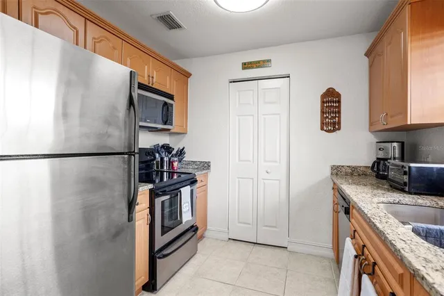a kitchen with stainless steel appliances granite countertop a refrigerator and a sink