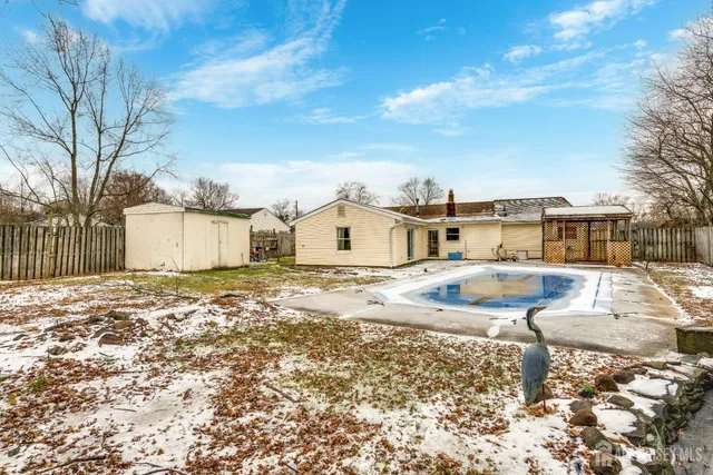 a view of a house with backyard and trees