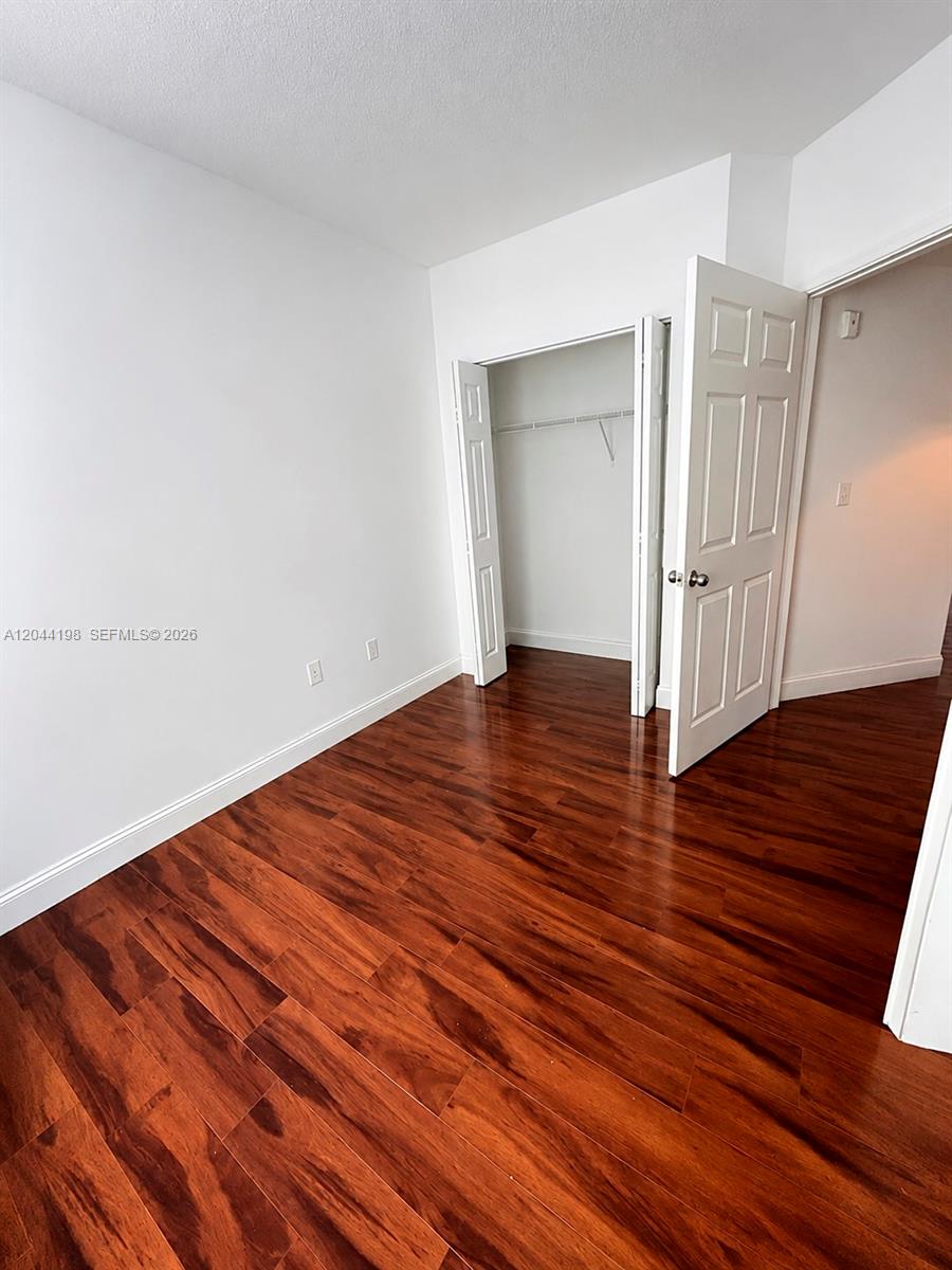 17145 North Bay Road, Unit 4307 Sunny Isles Beach, FL 33160 - Photo 18 of 35 a view of an empty room with wooden floor and closet