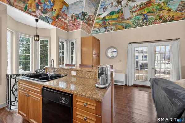 a kitchen with stainless steel appliances granite countertop a refrigerator a stove and a sink with wooden floor