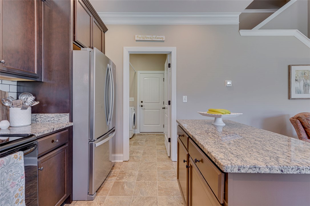 203 Streams Way Anderson, SC 29625 - Photo 23 of 47 This spacious kitchen offers a seamless flow into an adjacent laundry area and provides a clear view of the stairway.