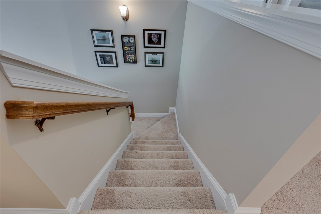 203 Streams Way Anderson, SC 29625 - Photo 27 of 47 This carpeted staircase, featuring a classic wooden handrail, invites seamless movement between floors.