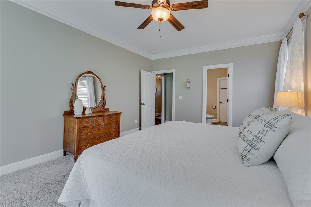 203 Streams Way Anderson, SC 29625 - Photo 9 of 47 This serene sleeping area provides a tranquil retreat, featuring elegant crown molding and soft, inviting carpet.