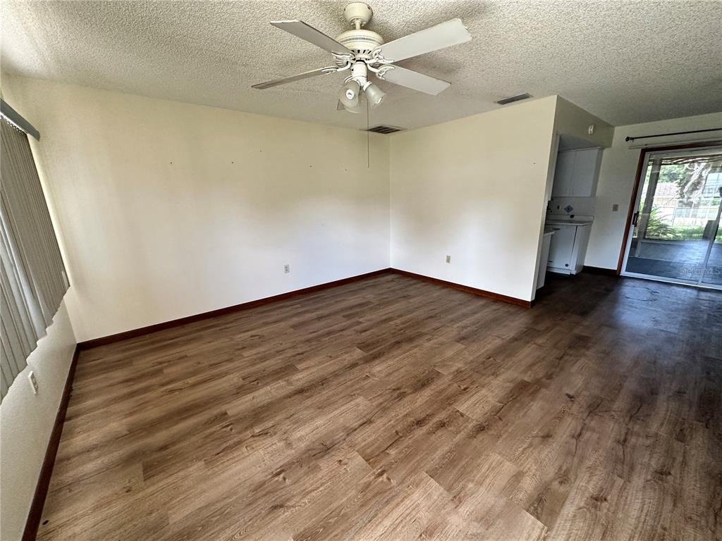 11150 Southwest 76th Avenue Ocala, FL 34476 - Photo 2 of 12 an empty room with wooden floor and fan