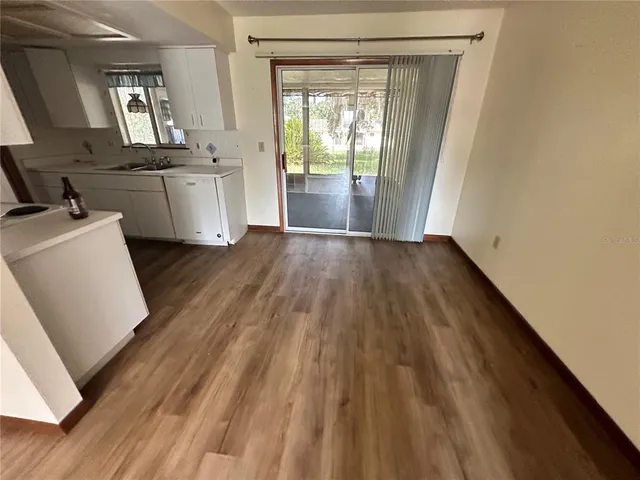 a view of a kitchen with wooden floor and electronic appliances