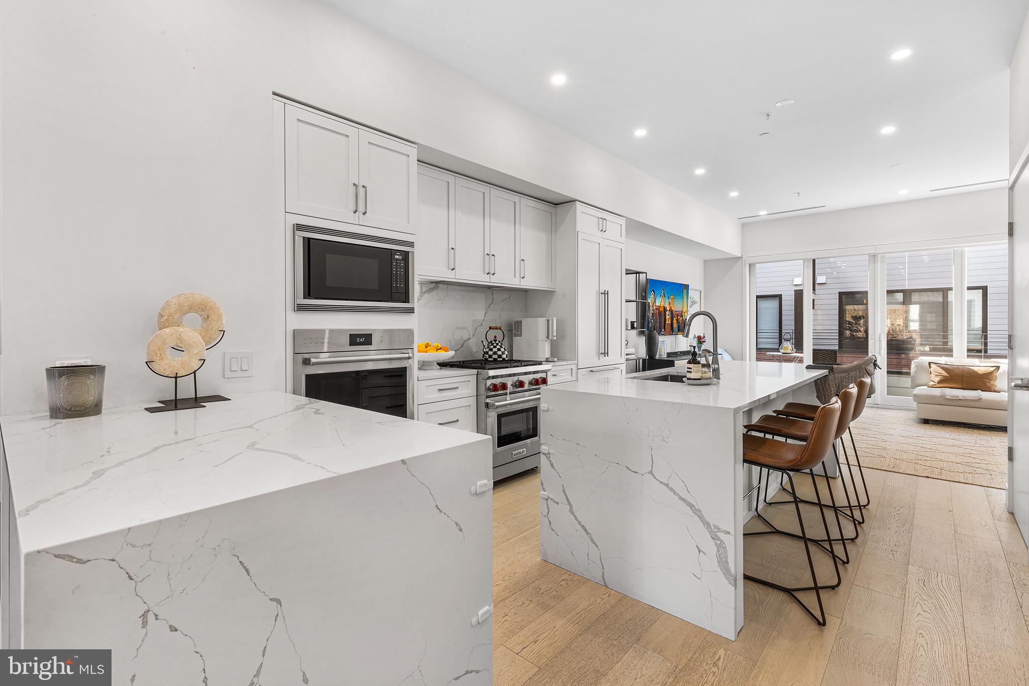 116 North Croskey Street Philadelphia, PA 19103 - Photo 1 of 57 a kitchen with stainless steel appliances kitchen island granite countertop a stove a sink a dining table and chairs with wooden floor