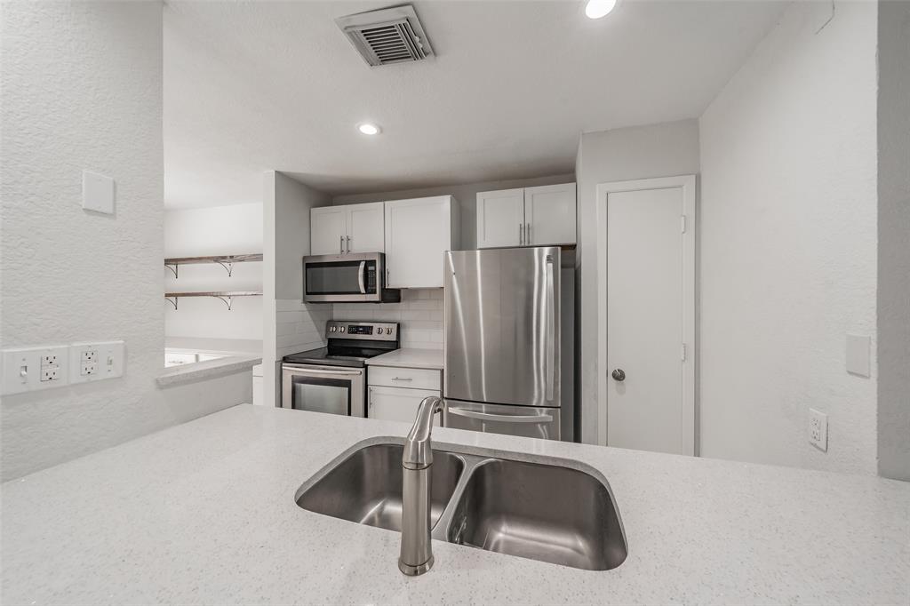 193 Merlin Way Euless, TX 76039 - Photo 11 of 35 Kitchen featuring a double basin stainless steel sink, stainless steel appliances, and a white subway tile backsplash