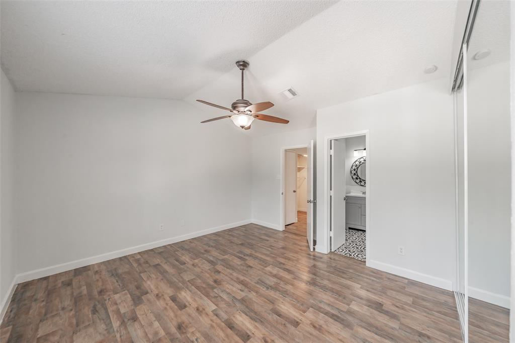 193 Merlin Way Euless, TX 76039 - Photo 26 of 35 Spacious bedroom featuring vinyl wood look flooring, a ceiling fan, and a closet with mirrored sliding doors