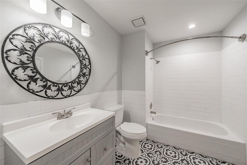 193 Merlin Way Euless, TX 76039 - Photo 30 of 35 Bathroom featuring patterned floor tiles, a white subway tile wainscoting, and a single vanity with a white countertop