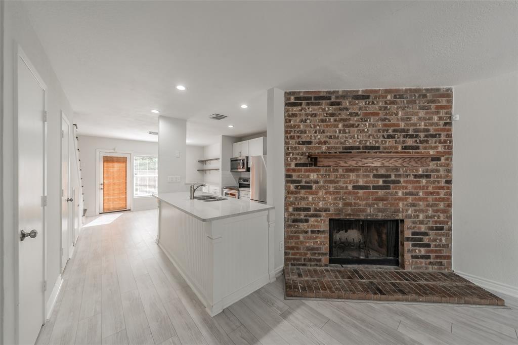 193 Merlin Way Euless, TX 76039 - Photo 5 of 35 Brick fireplace in living room open to kitchen & dining room.
