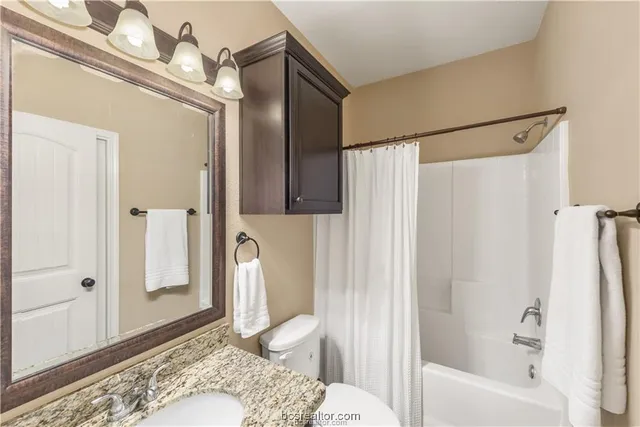 a bathroom with a tub shower and sink