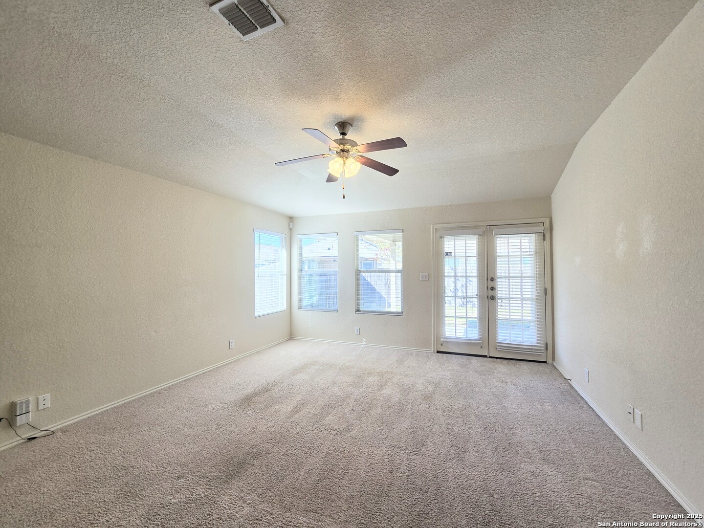 2711 Skybound San Antonio, TX 78245 - Photo 15 of 23 an empty room with chandelier fan and windows