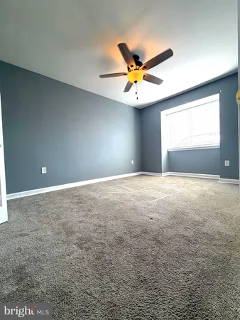 a view of a big room with a fan and a window