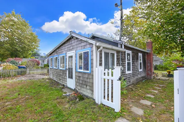 front view of a house with a yard table and chairs