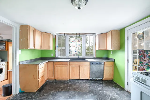 a kitchen with stainless steel appliances granite countertop a sink and a refrigerator