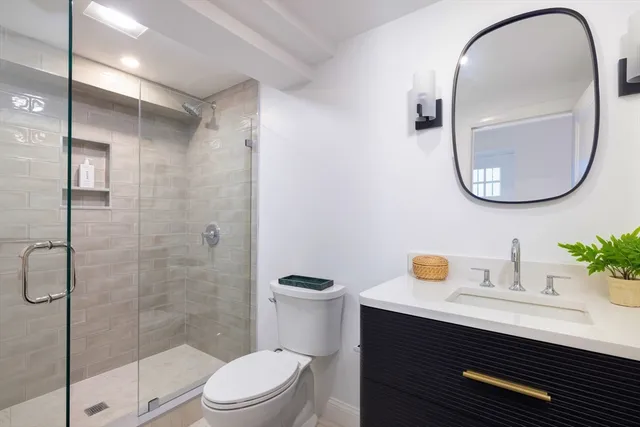 a bathroom with a sink a toilet and a mirror